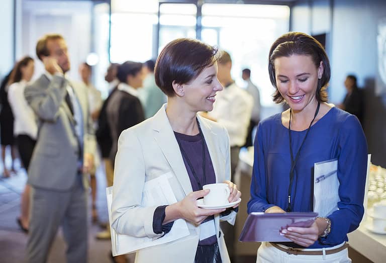 Exhibitors at a professional conference. Two people talking.