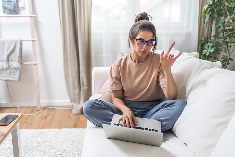 Woman at home using laptop to find information online. 