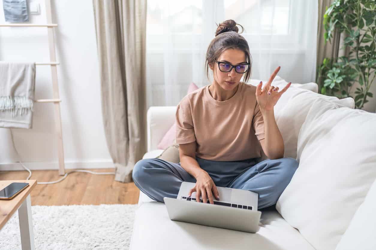Woman at home using laptop to find information online.