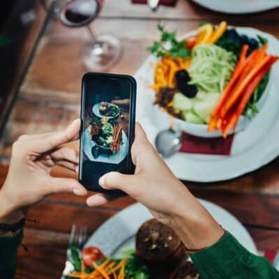 Image of person using cell phone to photograph a plate of food