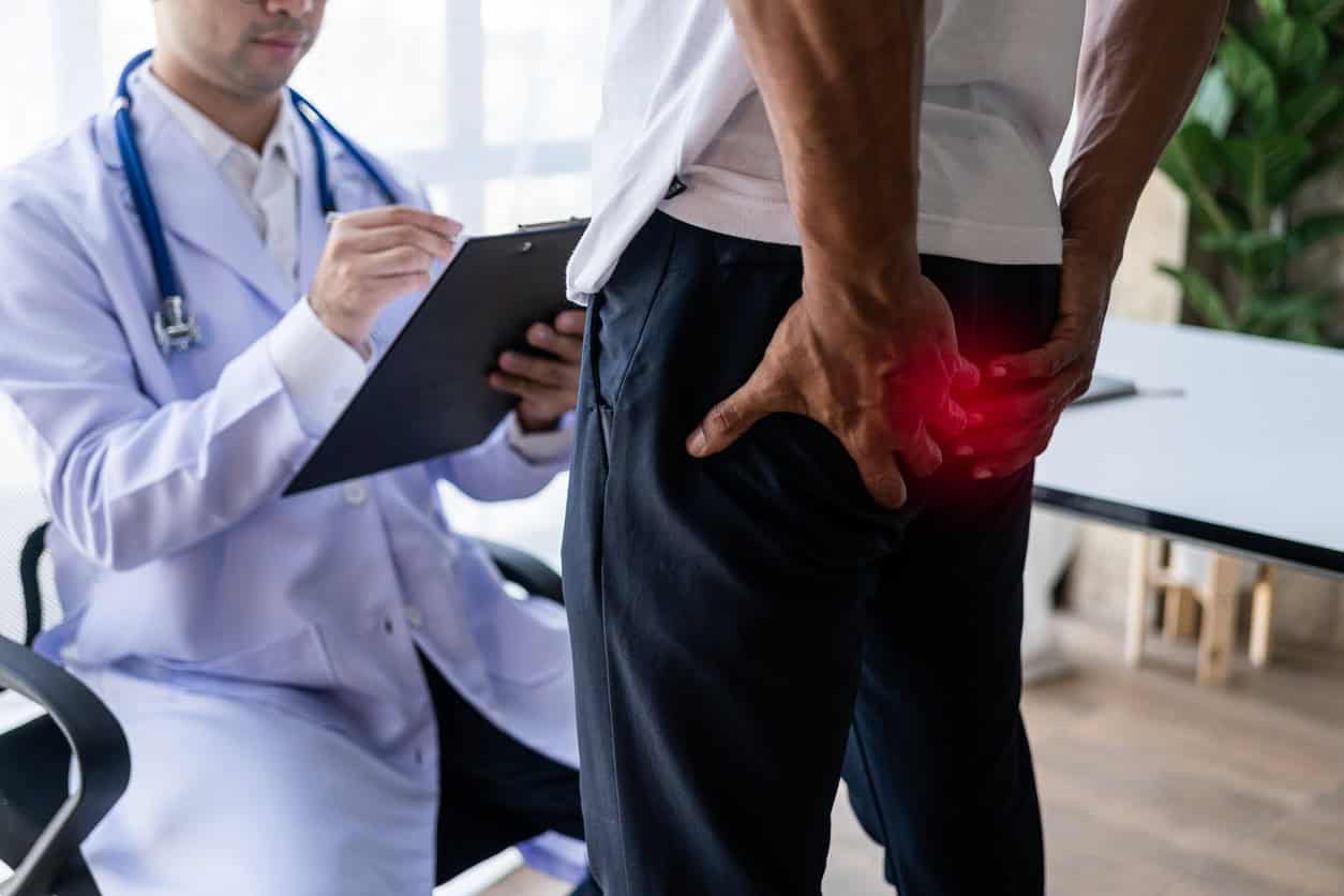 Photo of a male patient talking about hemorrhoids with his male doctor.
