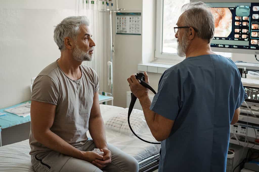 This is a photo photo of doctor and patient discussing imaging of the digestive tract, colon.