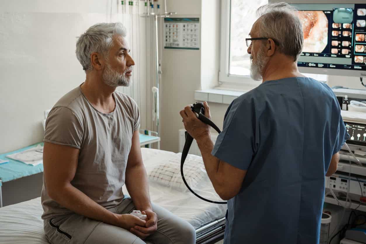 This is a photo photo of doctor and patient discussing imaging of the digestive tract, colon.