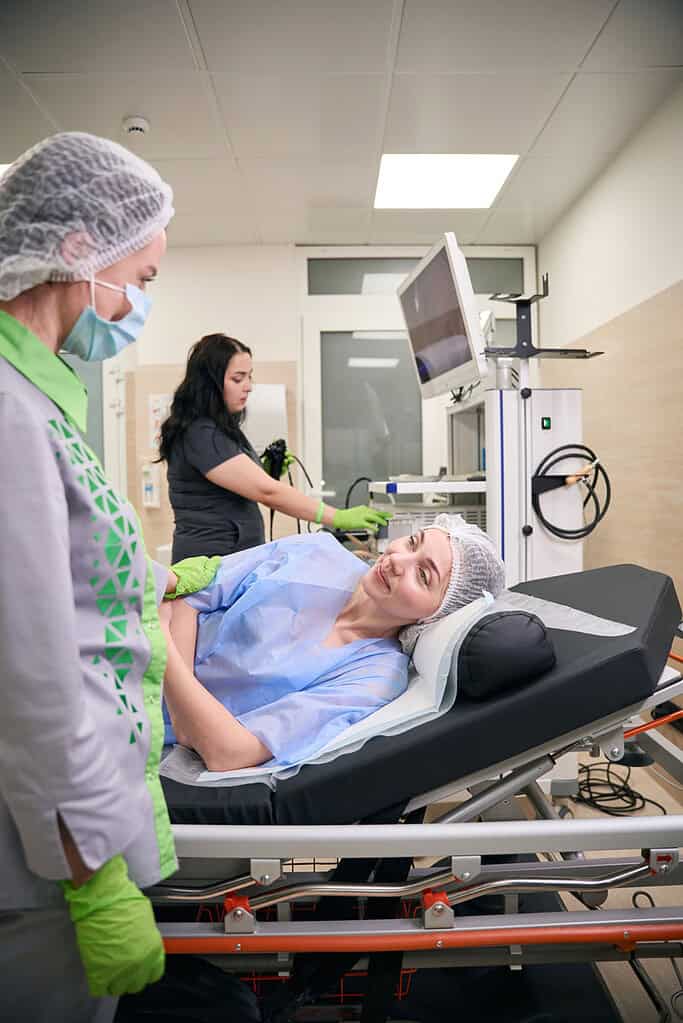 Image of female patient talking to doctor before colonoscopy. Pictured at the bedside.